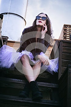 a ballerina at sunset on a cold evening reflects on life sitting on the stairs