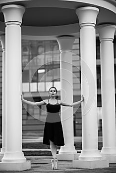 Ballerina in a tutu and pointe shoes makes a beautiful pose. Black and white photo.A beautiful young woman in a black