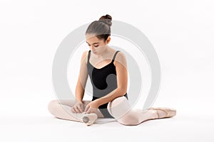 Ballerina tying the laces on her ballet shoes