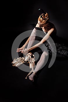 Ballerina tying pointe shoes.