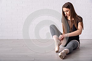 Ballerina tying shoes