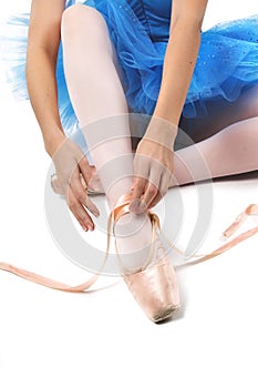 Ballerina tying shoes