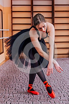 Ballerina Wearing black Tutu dance in training hall.