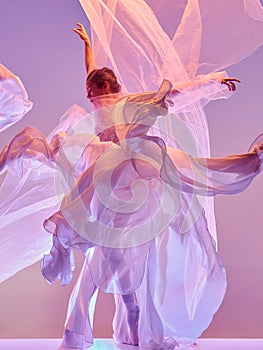 Ballerina. Young graceful female ballet dancer dancing over pink studio. Beauty of classic ballet.