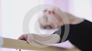 Ballerinas hand on barre. Blur background