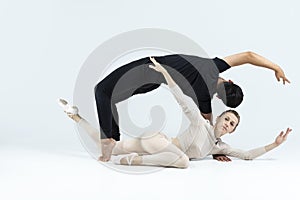 Ballet Concepts. Asian Young Man and Caucasian Woman Performing As Ballet Dancers Over Grey Studio Background Doing Suppots As