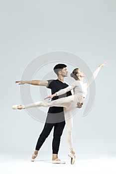 Ballet Concepts. Asian Young Man and Caucasian Woman Performing As Ballet Dancers Over Grey Studio Background Doing Suppots As