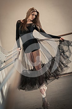 Ballet dancer at ballet barre on a tiptoe