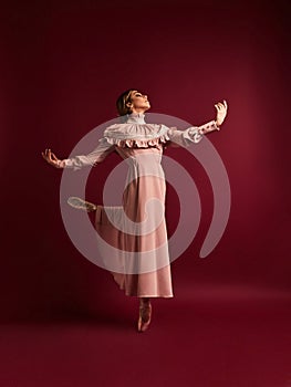 Ballet dancer or classic ballerina dancing isolated on red background. The dance, grace, artist, contemporary, movement, action