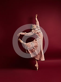 Ballet dancer or classic ballerina dancing isolated on red background. The dance, grace, artist, contemporary, movement, action