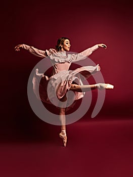 Ballet dancer or classic ballerina dancing isolated on red background. The dance, grace, artist, contemporary, movement, action