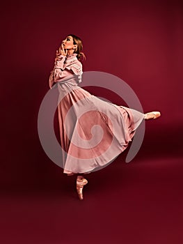Ballet dancer or classic ballerina dancing isolated on red background. The dance, grace, artist, contemporary, movement, action