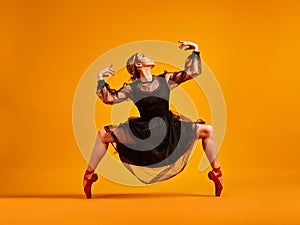 Ballet dancer or classic ballerina dancing isolated on yellow background. The dance, grace, artist, contemporary, movement, action