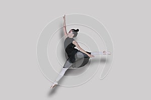 Ballet dancer doing jump exercises with graceful poses in studio