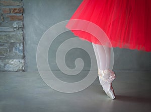 Ballet dancer legs with pointe shoes and coral tutu