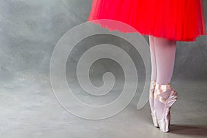 Ballet dancer legs on pointes, grey background