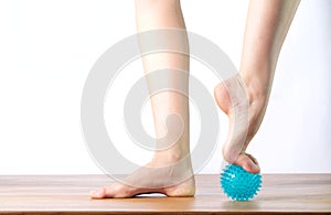 Ballet dancer massage the forefoot with a ball photo