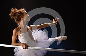 Ballet dancer posing by bar