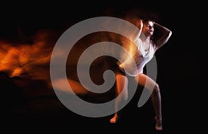 Ballet dancer posing on black studio background