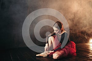 Ballet dancer tying pointe shoes