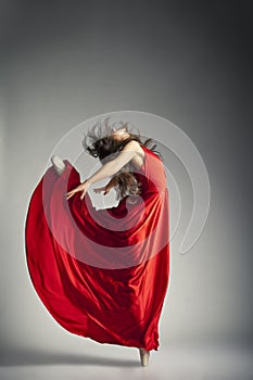 Ballet dancer wearing red dress over grey