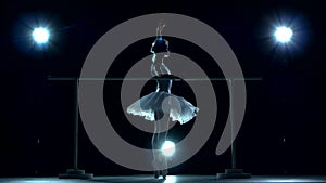 Ballet dancer in white tutu on one leg at ballet