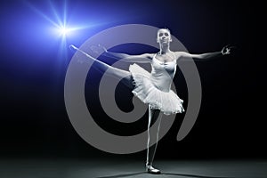 Ballet dancer in white tutu posing on one leg