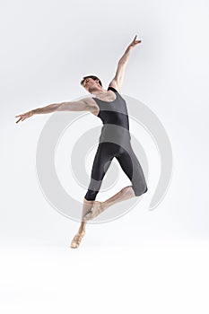 Ballet Dancer Young Athletic Man in Black Suit Posing in Stretching Pose Studio On White