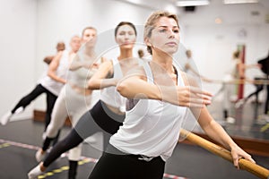 Ballet dancers practicing at barre in dance class