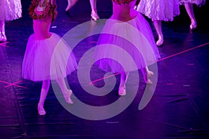 Ballet Dancers under Purple Light with Classical Dresses performing a ballet on Blur Background