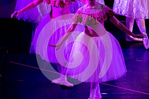 Ballet Dancers under Purple Light with Classical Dresses performing a ballet on Blur Background