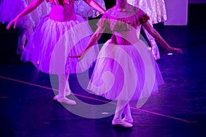 Ballet Dancers under Purple Light with Classical Dresses performing a ballet on Blur Background