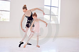Ballet, elegance and dancing instructor teaching a little ballerina movement and posture at a dance studio. Teacher