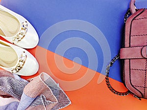 Ballet flat lady shoes and purple bag on red and blue background