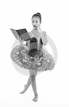 Ballet girl with book. Small girl study and train, education. Small ballerina reading book. She is in love with ballet