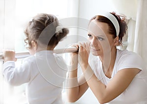 Ballet instructor directs little ballerina during dance practi