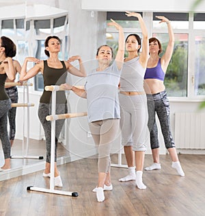 Ballet lesson for amateurs - choreographer teaches women of different ages different ballet steps in studio