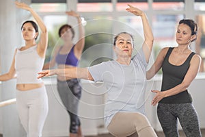 Ballet lesson for amateurs - choreographer teaches women of different ages different ballet steps in studio