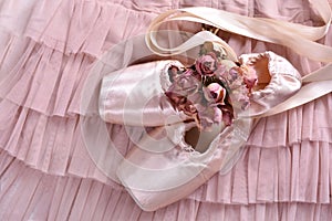 Ballet pointe shoes lying on tulle dress