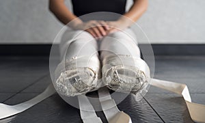 Ballet pointe shoes on a young female ballerina untied in ballet class
