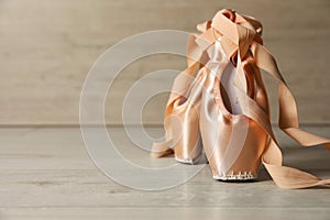 Ballet shoes. Elegant pointes on wooden floor indoors, space for text