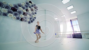 Ballet studio with a female dancer practicing in it