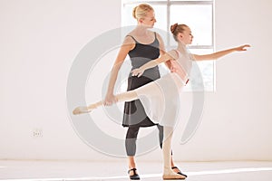 Ballet teacher teaching a student in a dance class or studio at an art school for coaching or learning. Young girl