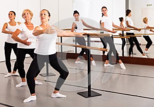 Ballet troupe of different ages in lesson in dance class photo