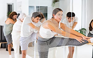 Ballet troupe doing warm-up at the barre in dance studio