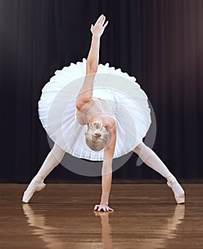 Ballet woman dancer, dancing on a theatre stage and doing a creative artistic performance. Training to dance means