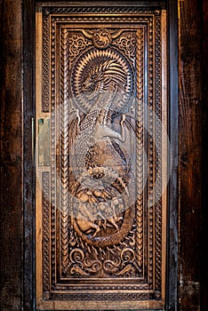 BALLINTOY HARBOUR, NORTHERN IRELAND, DECEMBER 20, 2018: Magnificent carved door with dragons and Dothraki horses, made with wood