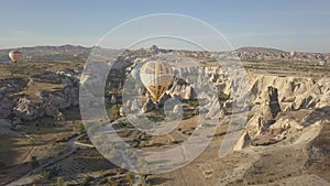 A balloon in the center of the frame against the background of mountains at dawn in summer