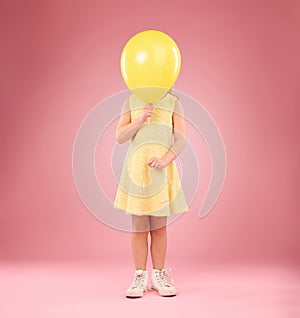 Balloon cover face, girl and child in studio isolated on a pink background mockup. Children, birthday party and