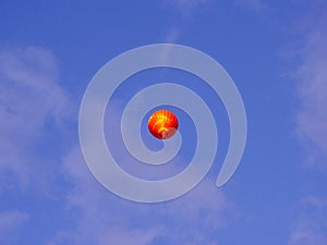 Balloon hot-air red, flying in blue sky with clouds